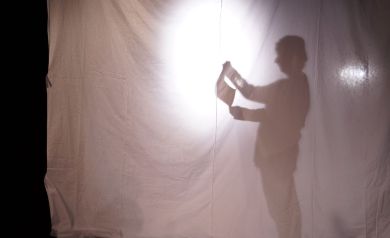 Zdjęcie przedstawia teatr cieni, na którym widoczna jest sylwetka jednej osoby. 