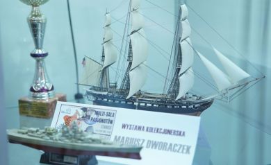 Zdjęcie przedstawia wystawę kolekcjonerską Mariusza Dworaczka. Na zdjęci widać dwa statki i puchar.