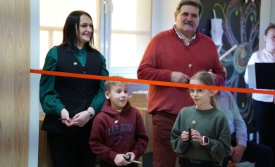 Na zdjęciu kobieta mężczyzna i dwójka dzieci. Przed nimi czerwona wstęga. Wszystkie osoby widoczne za zdjęciu trzymają w dłoniach nożyczki. 