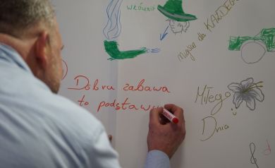 Mężczyzna piszący czerwonym markerem na płótnie.