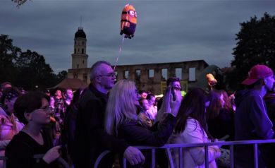 Publiczność słucha występu i robi zdjęcia.