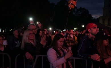 Publiczność macha światłami z telefonów w rytm melodii.