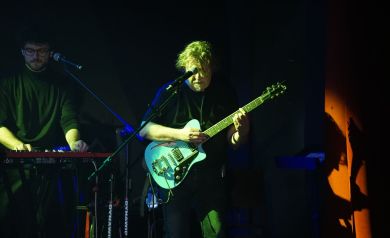 Zbliżenie na perkusistę i myzyka grającego na instrumentach klawiszowych