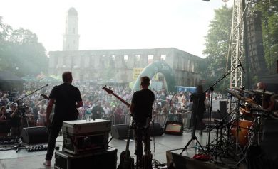 Muzycy na scenie. Publiczność ogląda występ.