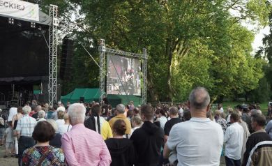 Publiczność bawi się podczas koncertu. Obok sceny telebim.