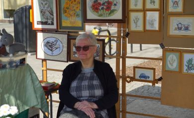 Sprzedawczyni z ręcznie haftowanymi obrazami haftem krzyżykowym.