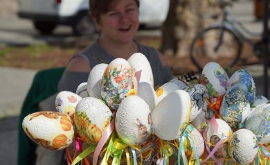 Kolorowe jajeczka styropianowe, wykonane metodą decopauge i ozdobione kolorowymi wstążkami na patyczkach.