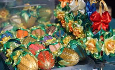 Żółte, pomarańczowe, czerwone jajeczka styropianowe ozdobione wstążkami i ręcznie robione wstążki. 