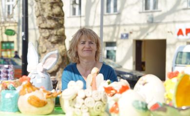 Pani sprzedaje wielkanocne ozdoby, kolorowe jajeczka i zajączki. 