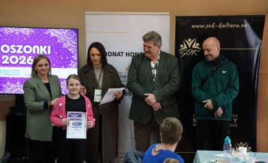 Dwie Panie i dwaj Panowie stoją, przed nimi dziewczynka z dyplomem