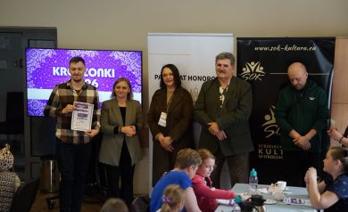 W tym samym gronie, mężczyzna znajdujący się całkowicie po lewej otrzymuje dyplom