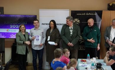 W tym samym gronie tym razem to mężczyzna w jasnej koszuli otrzymuje dyplom