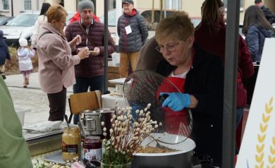 Pani z koła gospodyń wiejskich miesza wołowinę, którą można zakupić na jarmarku wielkanocnym. 