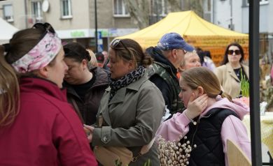Kupujący mieszkańcy wybierają ręcznie robione ozdoby na jarmarku wielkanocnym. 
