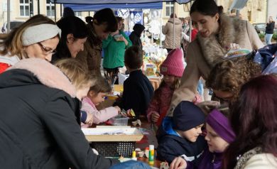 Pełne dzieci stanowisko warsztatów plastycznych, wszyscy szykują ozdoby wielkanocne. 