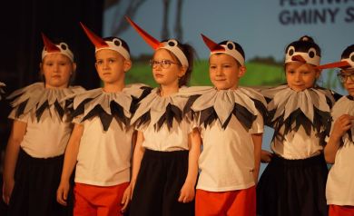 czworo dzieci przebranych za bociany na scenie sali widowiskowej