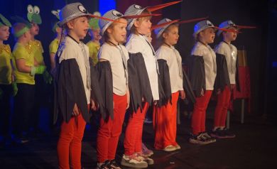 dziewczynki w przebraniu bociana śpiewają na scenie