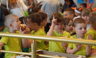 przedszkolaki w żółtych koszulkach częstują się poczęstunkiem w trakcie obrad jury