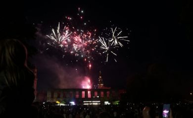 Zgromadzony tłum ogląda pokaz sztucznych ogni nad ruinami zamku.