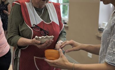 Kobiety porównują małe formy do misek z z gotową rzeźbą.