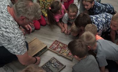 Prowadzący pokazuje dzieciom pastele.