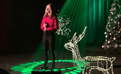 Piosenkarka na scenie wśród świątecznych ozdób 