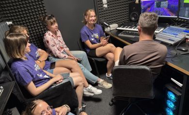 Na zdjęciu sześć osób znajdujących się w studio nagrań. Wokół nich znajduje się różny sprzęt m.in. do nagrań. - powiększ
