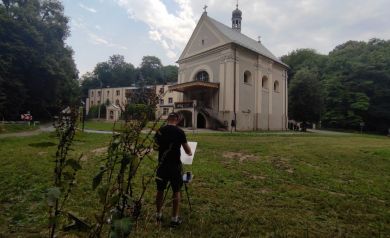 Artysta pracujący przy sztaludze.