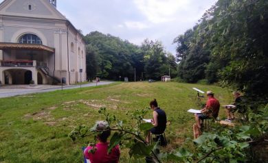 Grupa artystów malująca kościółek w Porębie.