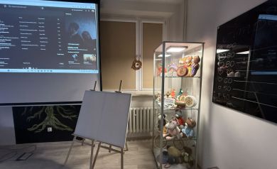 Zbliżenie na sztalugi, witrynę ekzpozycyjną oraz tablicę szklaną w pracowni - powiększ