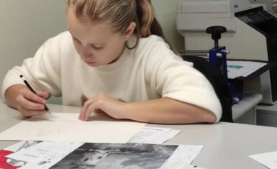 Na zdjęciu dziewczyna szkicująca obraz. 