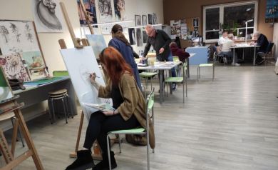 Uczestnicy zajęć plastycznych pracujący nad swoimi dziełami. 