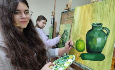 Na zdjęciu dwie dziewczyny. Malują pędzlami swoje dzieła. 