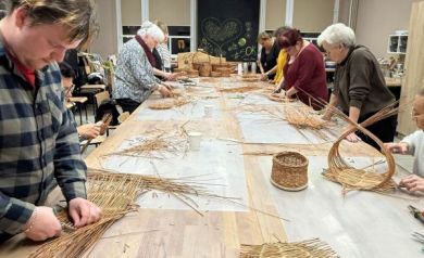 Na zdjęciu osoby tworzące dzieła z wikliny. 