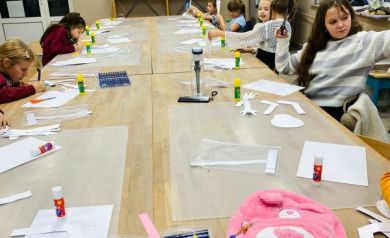 Dzieci pracujące podczas zajęć kreatywnych. Na zdjęciu również przybory do tworzenia prac plastycznych. 