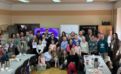 Grupa ludzi pozująca do zdjęcia, część z dyplomami