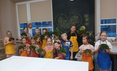 Zdjęcie grupowe uczestników wraz z pracami wykonanymi podczas warsztatów z tworzenia ,,Drzewek Życia'. 